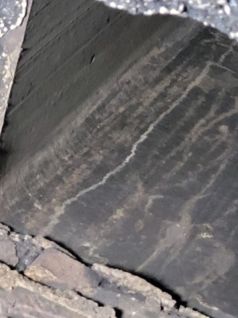 Vertical crack in a chimney flue liner with signs of soot buildup.